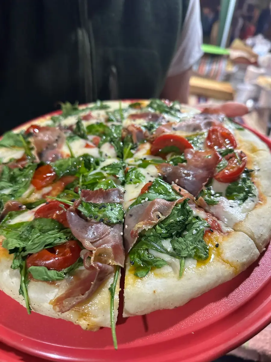 Pizza especial con rúcula, tomates y jamón